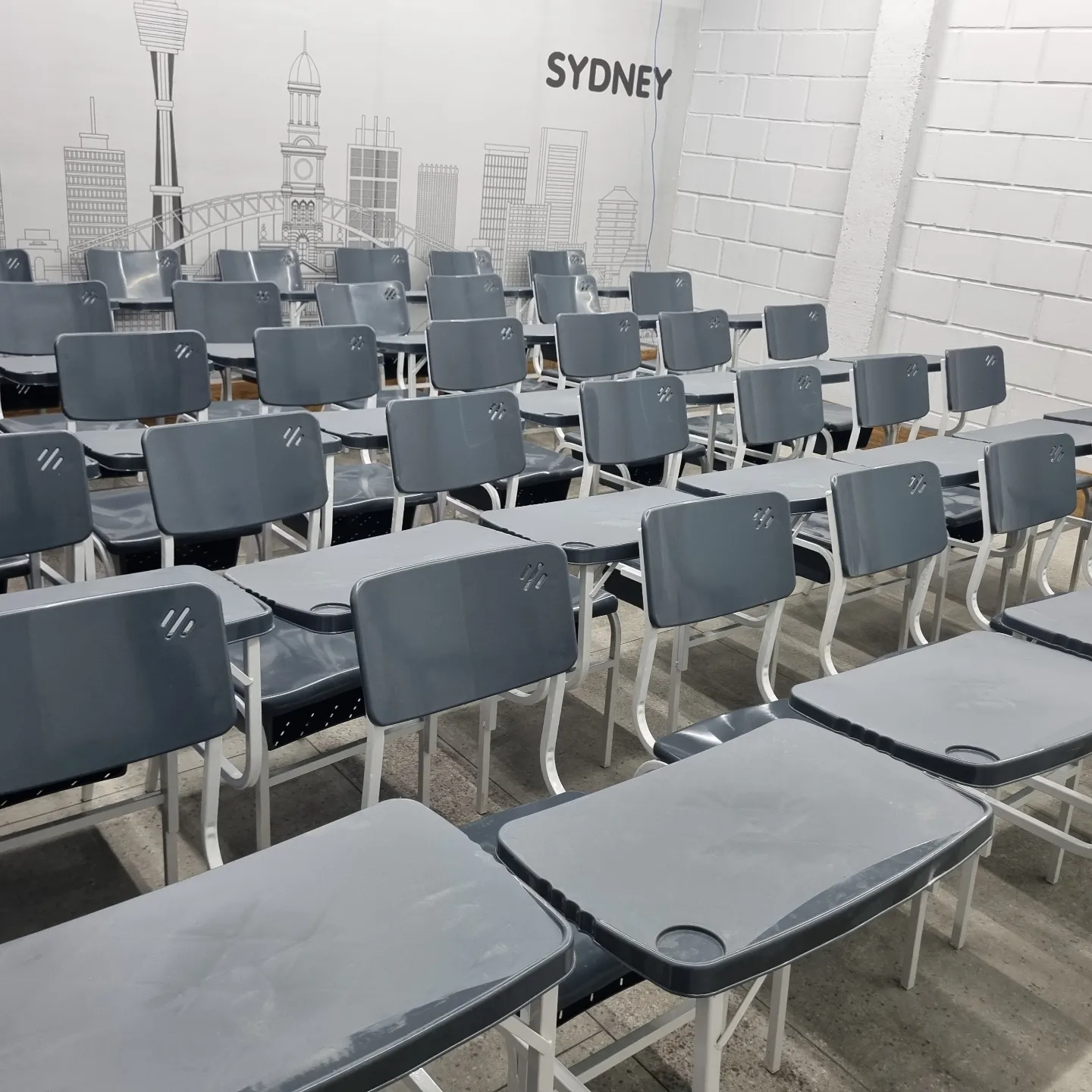 Sala de curso equipada com carteiras universitárias com prancheta da JB